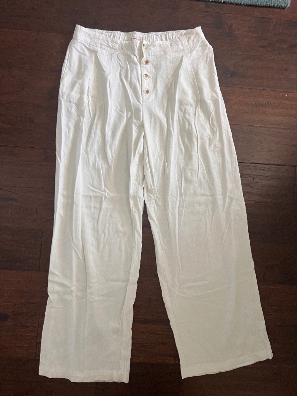 The ivory white pants featured in the image appear to be high-rise, wide-leg tro